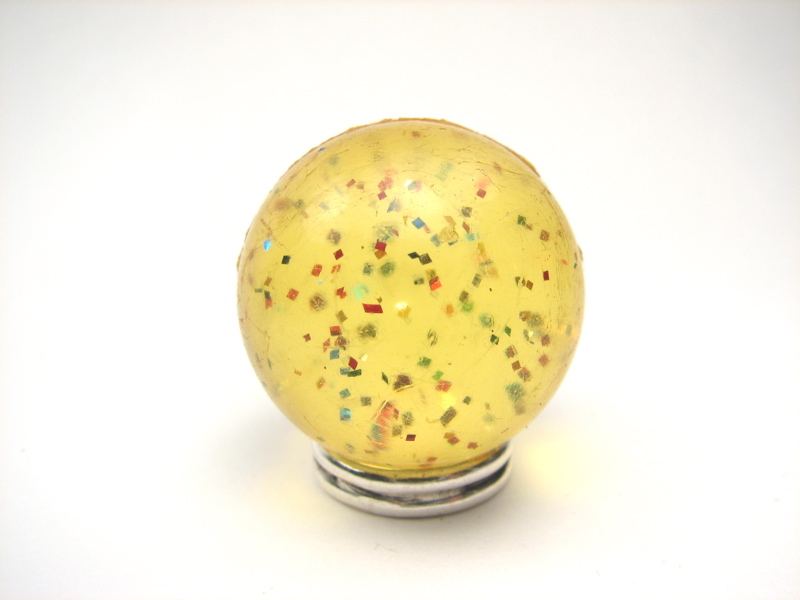 A speckled golden sphere on top of a metal stand
