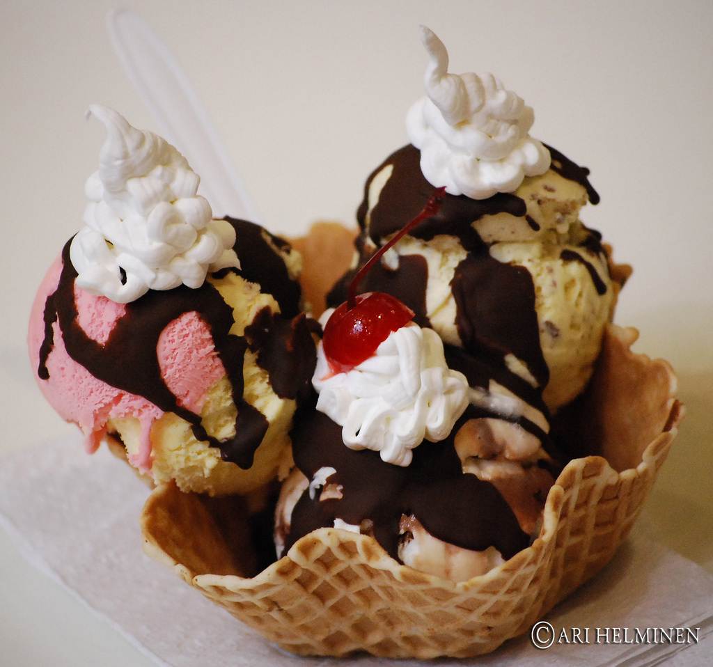 Several scoops of icecream in a waffle basket.